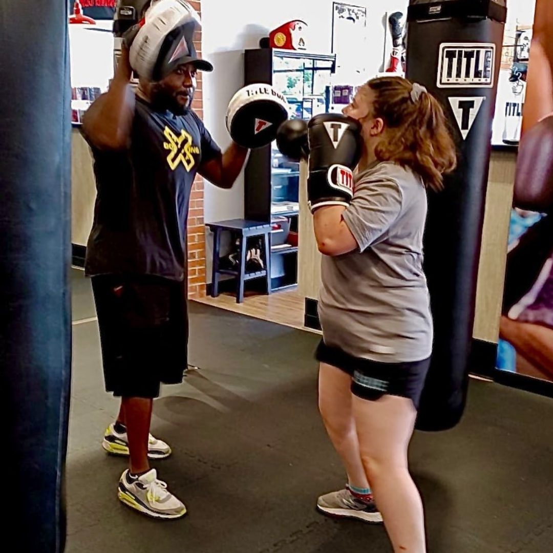 Coach Sean Archer coaching boxing pad work with a client